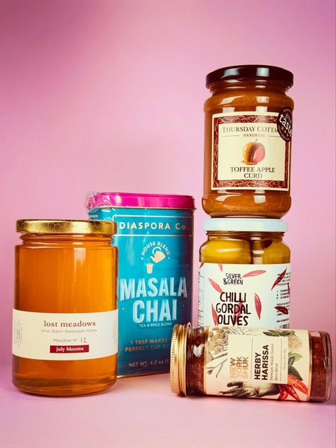 5 jars and tins of new products: Lost Meadows Honey, Diaspora Co Masala Chai tea and spice mix, Thursday Cottage Toffee Apple Curd, Silver and Green Chilli Gordal Olives and New York Shuk Herby Harissa
