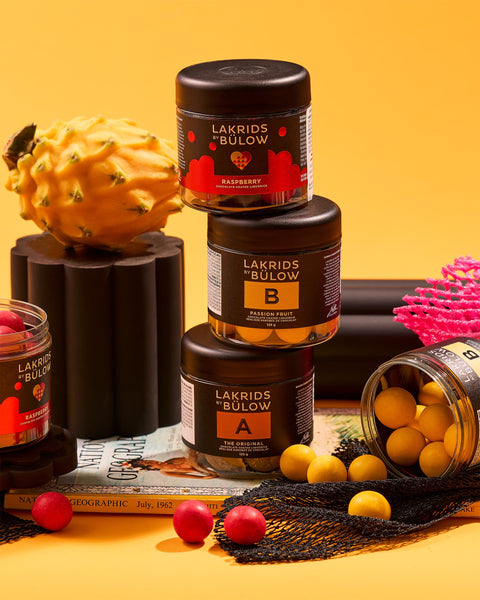 Lakrids by Bülow Chocolate Covered Liquorice Balls on a yellow surface