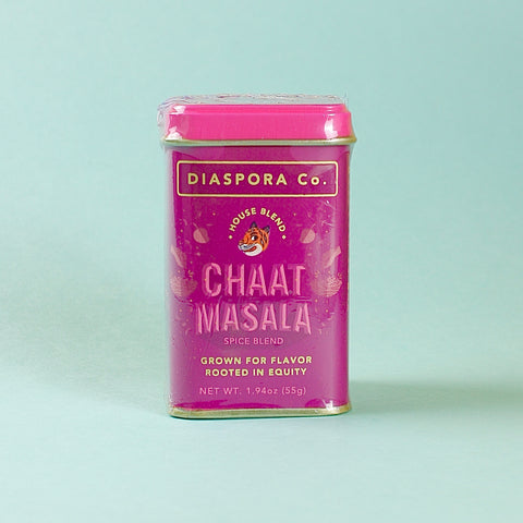 Pink canister of Diaspora Co. Chaat Masala spice blend on a light blue background