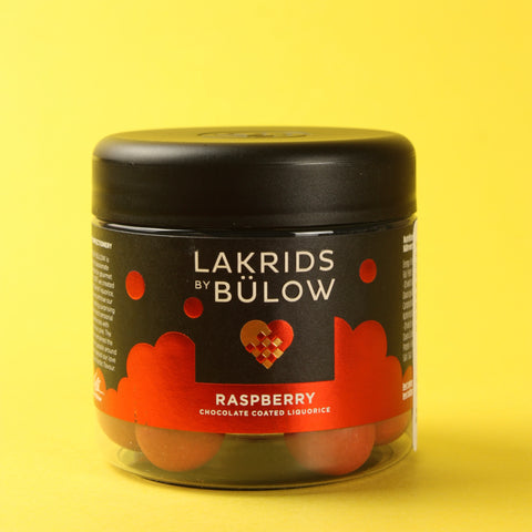 Jar of Lakrids by Bulow raspberry chocolate coated licorice on a yellow background
